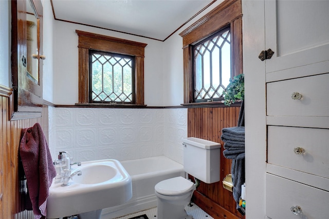 bathroom with a washtub, crown molding, a sink, and toilet