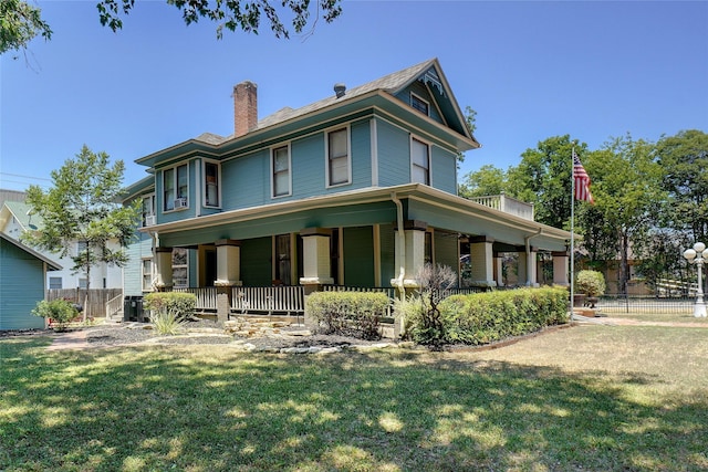 view of front of property featuring a chimney, fence, and a front lawn