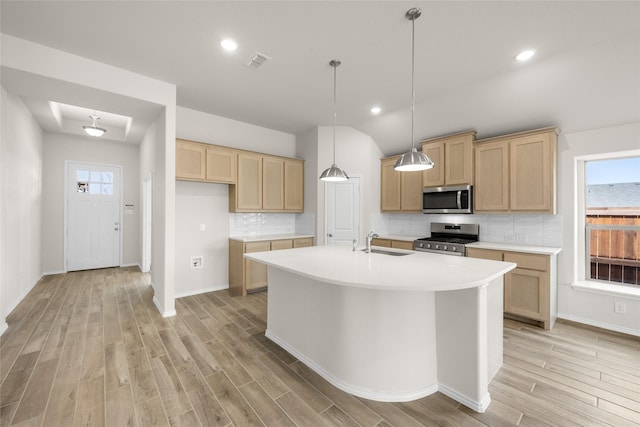 kitchen featuring visible vents, backsplash, light wood-type flooring, stainless steel appliances, and a sink