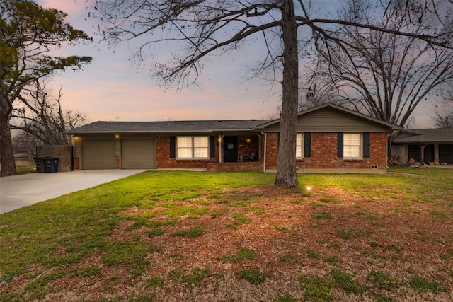 single story home with an attached garage, brick siding, concrete driveway, and a front yard