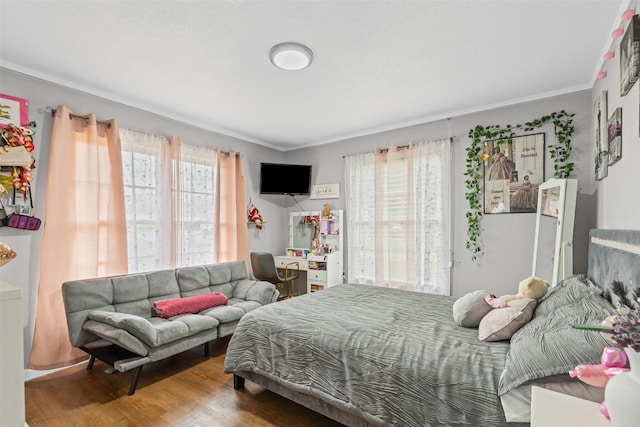 bedroom featuring crown molding and wood finished floors