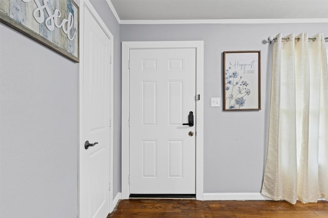 doorway featuring crown molding, baseboards, and dark wood-type flooring