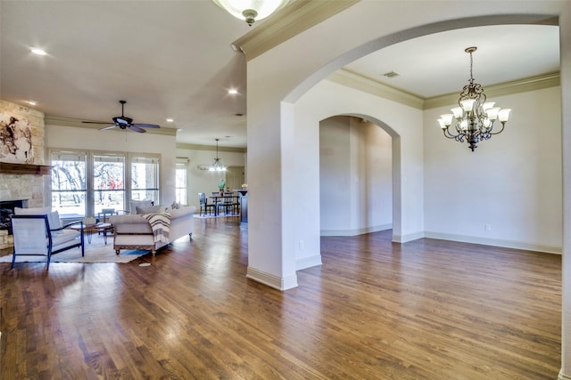 living room with baseboards, ornamental molding, dark wood finished floors, and a stone fireplace