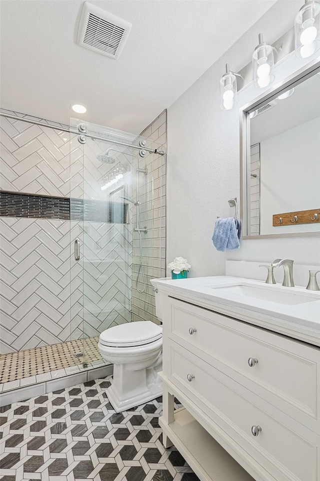 full bathroom with toilet, a shower stall, visible vents, and vanity