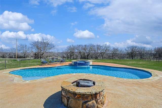 view of pool featuring a fire pit, a patio, fence, a yard, and a pool with connected hot tub