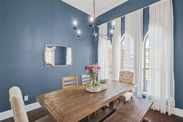 dining space with an inviting chandelier, crown molding, baseboards, and dark wood-style flooring