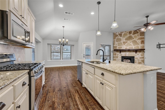 kitchen with hanging light fixtures, stainless steel appliances, a sink, and open floor plan