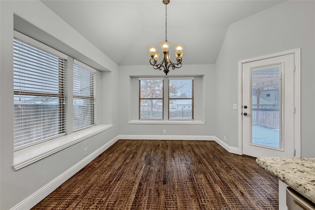 unfurnished dining area with lofted ceiling, baseboards, and a notable chandelier