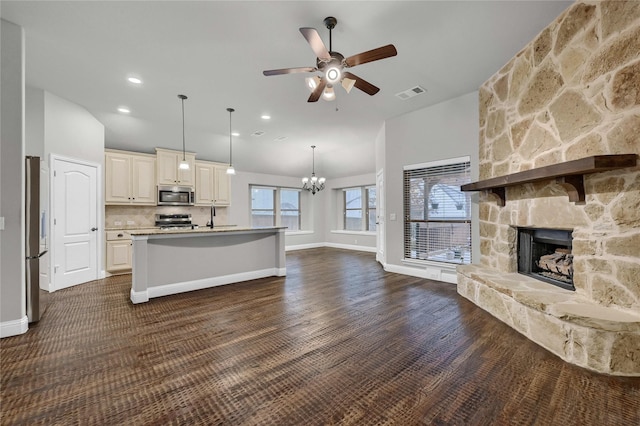 kitchen with a kitchen island with sink, visible vents, open floor plan, light countertops, and appliances with stainless steel finishes