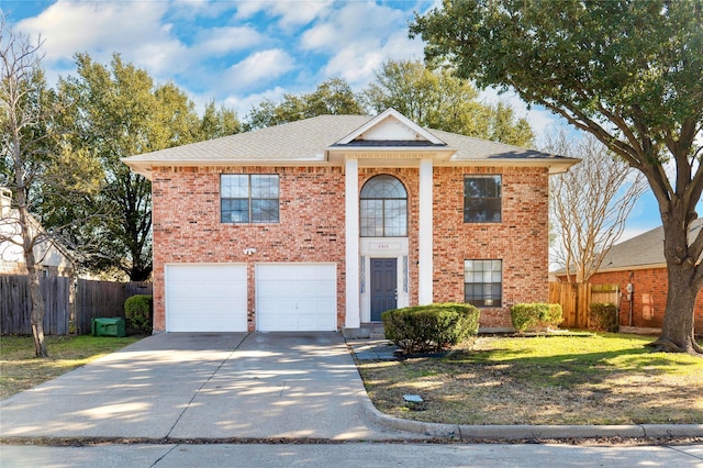 neoclassical home featuring a garage, fence, brick siding, and driveway