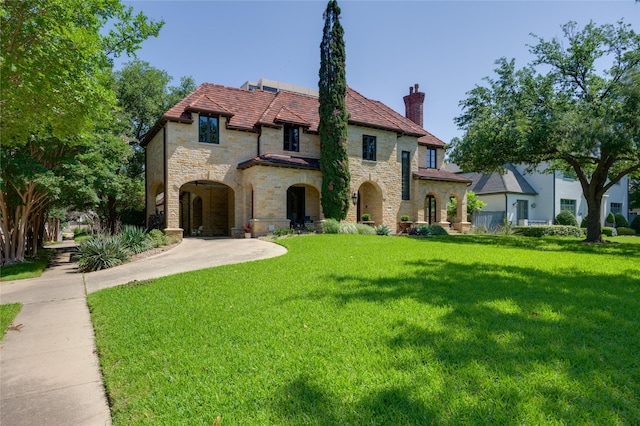 view of front of home featuring stone siding, a chimney, and a front yard