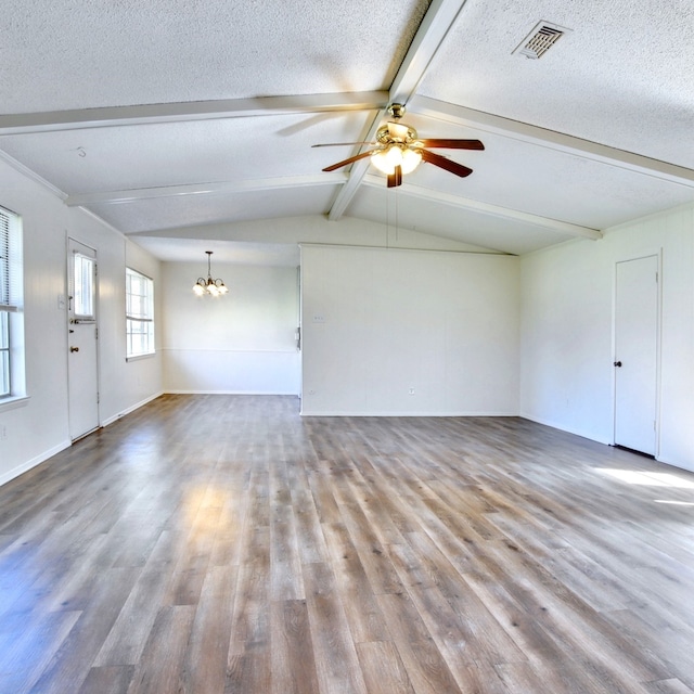 unfurnished living room featuring visible vents, lofted ceiling with beams, a textured ceiling, wood finished floors, and ceiling fan with notable chandelier