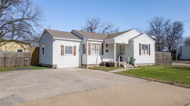 bungalow featuring driveway, a front lawn, a shingled roof, and fence