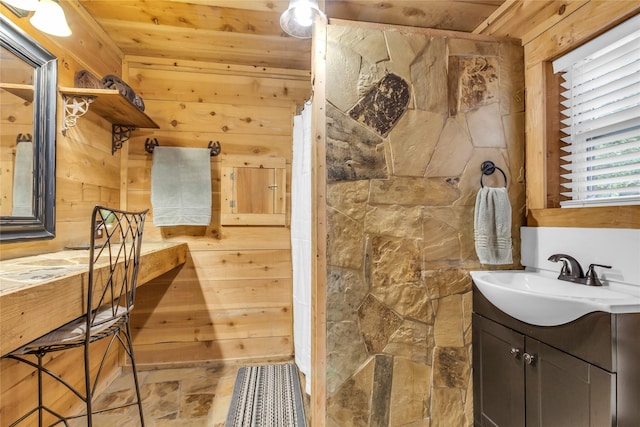 bathroom featuring wooden walls, vanity, and stone finish flooring