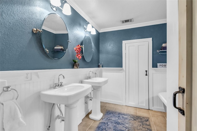 bathroom with tile patterned floors, a wainscoted wall, visible vents, and crown molding