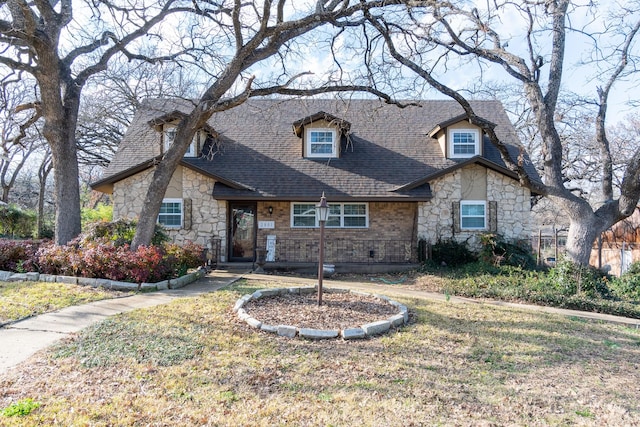 view of front of home with a shingled roof and a front lawn