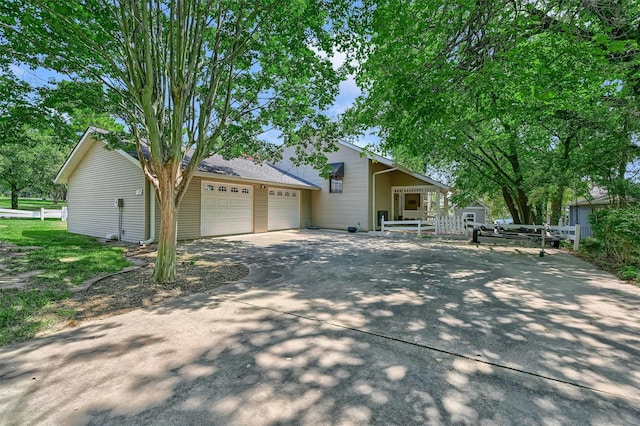 view of front of house with driveway, an attached garage, and fence