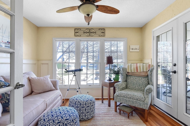 living area with french doors, wood finished floors, and a wealth of natural light