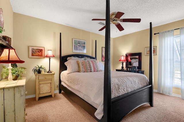 bedroom with light carpet, multiple windows, baseboards, and a textured ceiling