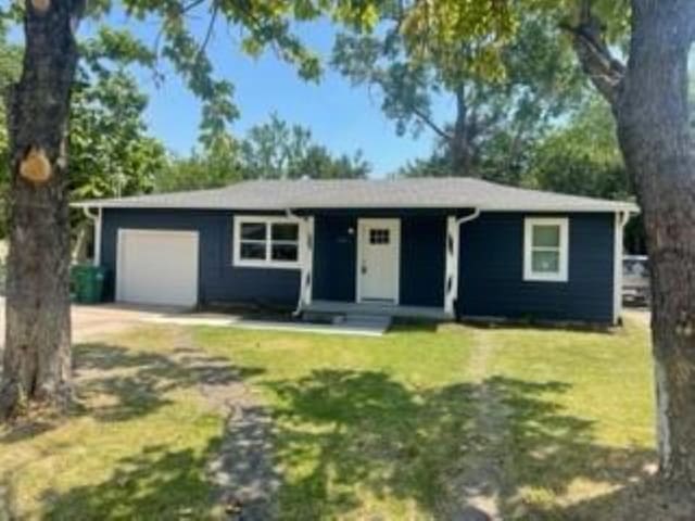 single story home featuring a front yard and an attached garage