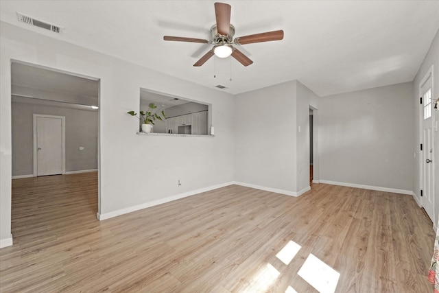 empty room featuring light wood-type flooring, visible vents, ceiling fan, and baseboards