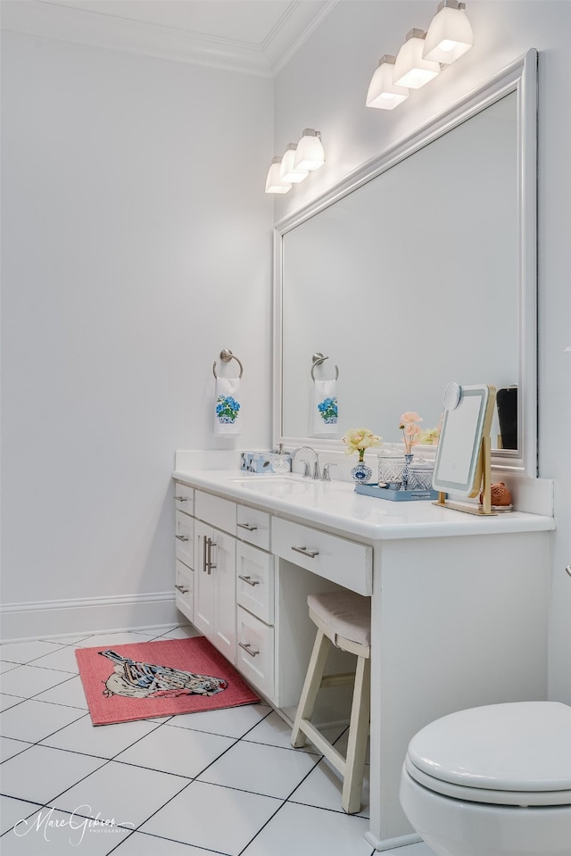 bathroom featuring toilet, ornamental molding, vanity, baseboards, and tile patterned floors