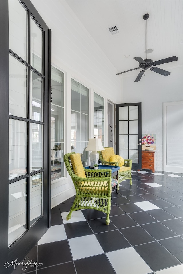 sunroom with ceiling fan and visible vents