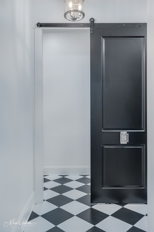 details featuring tile patterned floors, an inviting chandelier, and baseboards