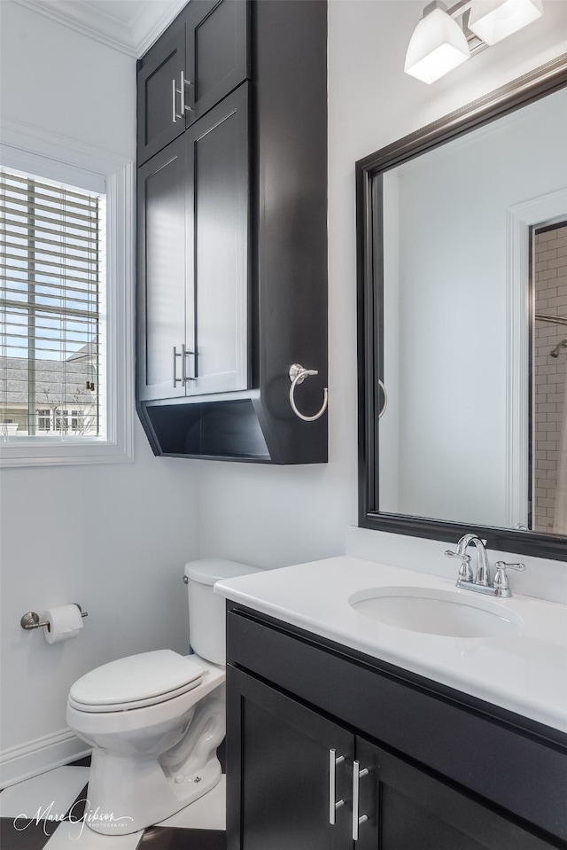 bathroom with ornamental molding, vanity, toilet, and baseboards