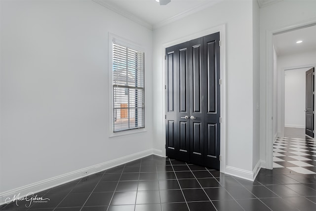 foyer featuring baseboards, dark tile patterned flooring, and crown molding