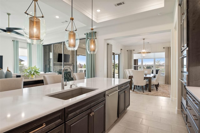 kitchen featuring visible vents, a sink, light countertops, pendant lighting, and stainless steel dishwasher