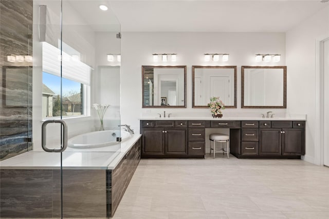 full bath featuring double vanity, a sink, and a bath