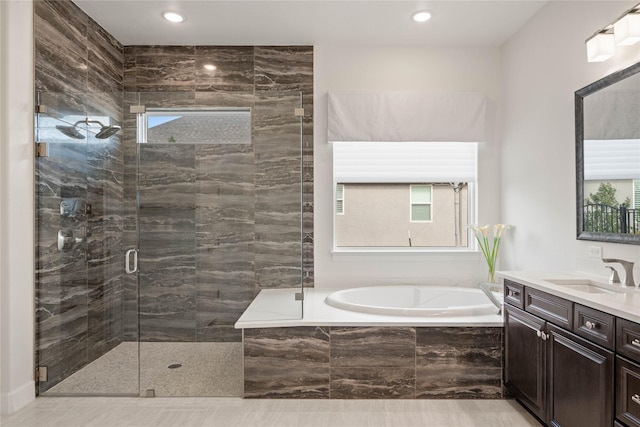 full bath with a garden tub, vanity, and a shower stall