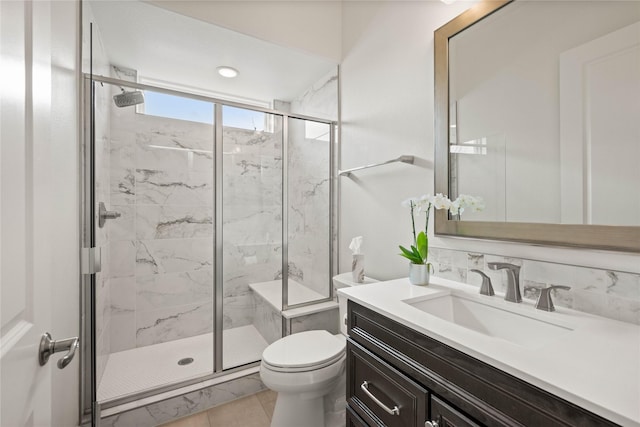 full bathroom featuring toilet, a marble finish shower, and vanity