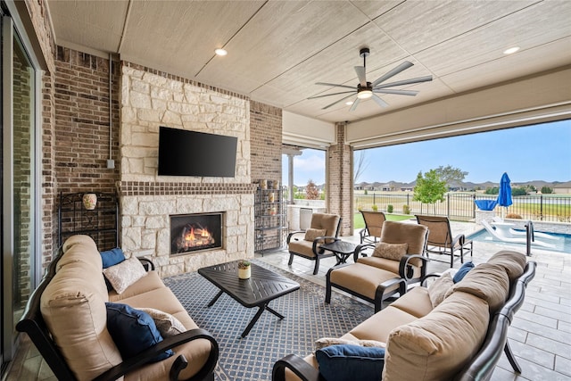 view of patio with a fenced in pool, fence, an outdoor living space with a fireplace, and ceiling fan