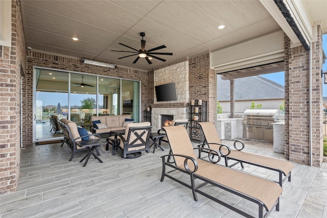 view of patio / terrace featuring a large fireplace and area for grilling