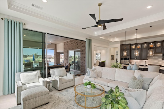 living room featuring ceiling fan, recessed lighting, visible vents, a raised ceiling, and crown molding