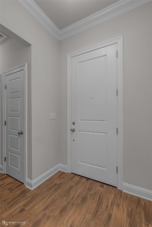 doorway to outside with baseboards, ornamental molding, and wood finished floors