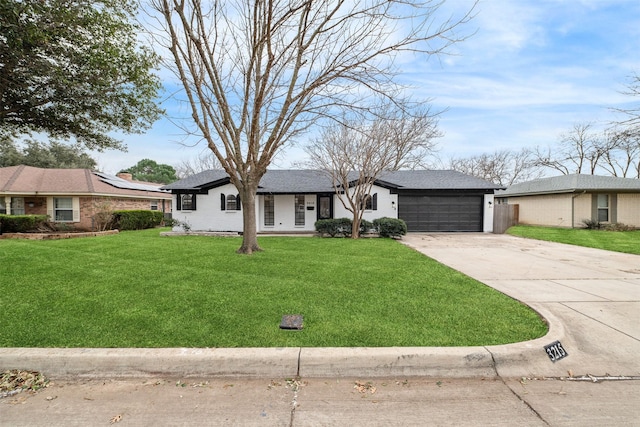 view of front of property featuring a garage, concrete driveway, and a front lawn