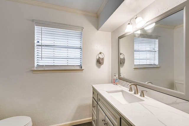 bathroom with a textured wall, toilet, ornamental molding, vanity, and baseboards