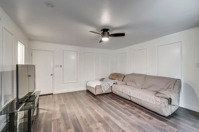 unfurnished living room with a ceiling fan, a decorative wall, ornamental molding, and wood finished floors