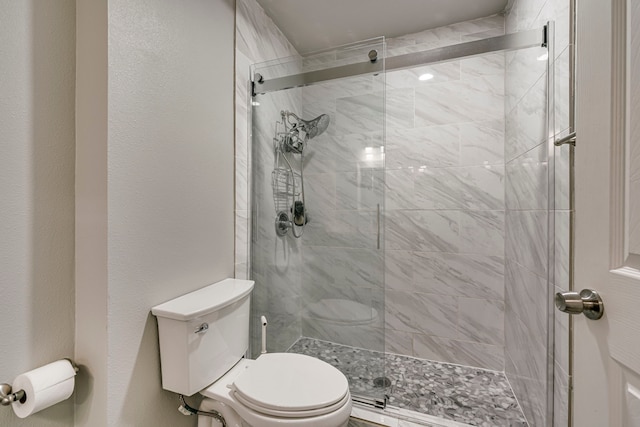 bathroom featuring a shower stall and toilet