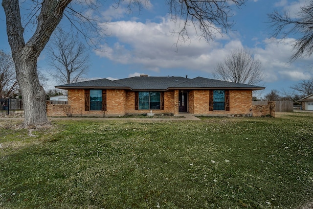 ranch-style home with a chimney, fence, a front lawn, and brick siding