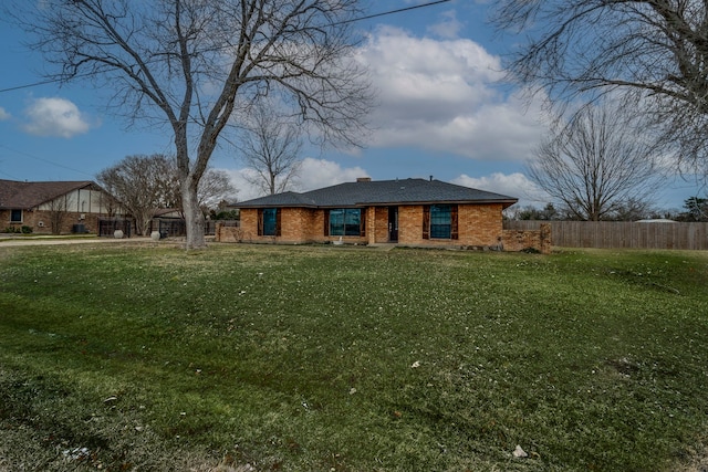 view of front of property with a front lawn, fence, and brick siding