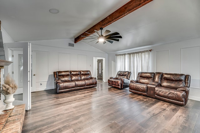 living area featuring visible vents, a decorative wall, lofted ceiling with beams, and wood finished floors