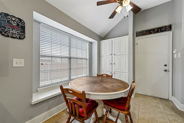 dining space with light tile patterned flooring, vaulted ceiling, baseboards, and ceiling fan