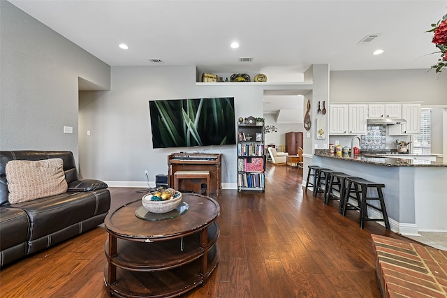 living room featuring baseboards, visible vents, dark wood finished floors, and recessed lighting