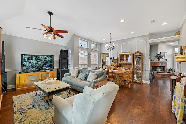 living area with visible vents, dark wood finished floors, ornamental molding, a brick fireplace, and recessed lighting