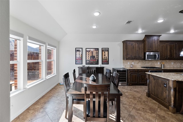 dining room with visible vents, baseboards, lofted ceiling, wine cooler, and recessed lighting