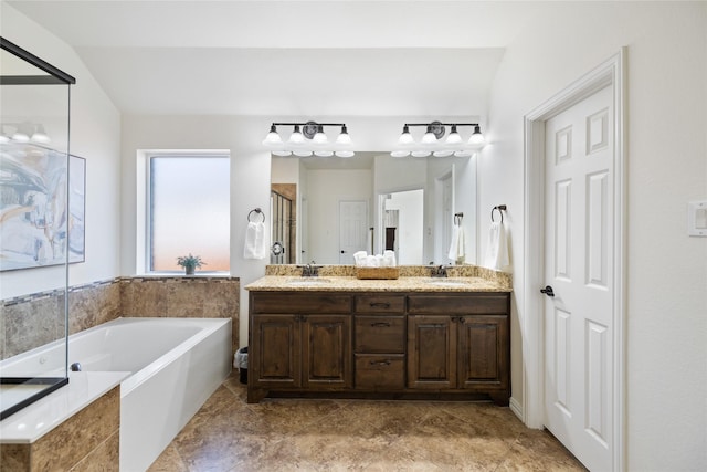 full bath with double vanity, a garden tub, a shower stall, and a sink